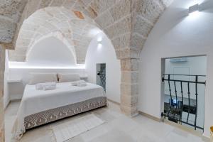 - une chambre avec un lit dans un mur en pierre dans l'établissement Suite L' Alcova, à Fasano