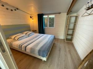 a bedroom in a tiny house with a bed at Maison MAHECO in Gujan-Mestras