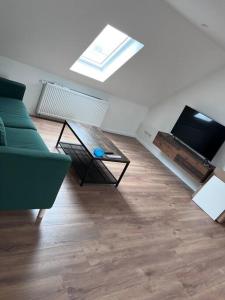 マクデブルクにあるschicke Wohnung im Herzen von Magdeburgの緑のソファとテーブルのあるリビングルーム