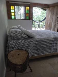 a bedroom with a bed and a table and windows at mountain cabin for bird watching in Sabaneta
