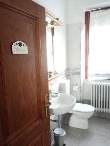a bathroom with a toilet and a sink and a door at B&B BORGHI in Poppi
