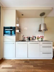 a kitchen with white cabinets and a sink at Premium Apartment Falkensteiner in Petrcane