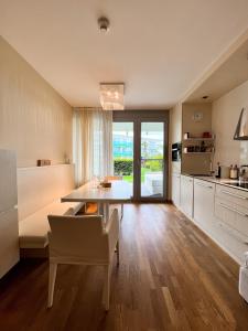 uma cozinha com uma mesa e uma sala de jantar em Premium Apartment Falkensteiner em Petrcane