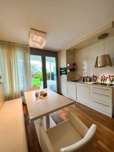een keuken en een woonkamer met een tafel en stoelen bij Premium Apartment Falkensteiner in Petrcane
