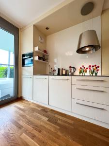 a kitchen with white cabinets and a large window at Premium Apartment Falkensteiner in Petrcane