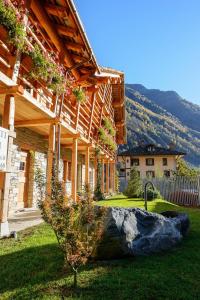 a wooden house with a rock in the yard at Baite Rosa in Alagna Valsesia