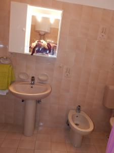 La salle de bains est pourvue d'un lavabo, de toilettes et d'un miroir. dans l'établissement Apartment Štrmac, à Labin