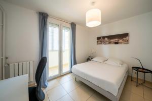 a bedroom with a bed and a large window at Cozy and spacious apartment well furnished in Montpellier