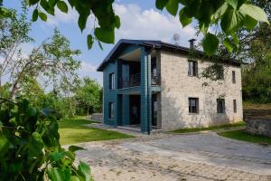 uma velha casa de pedra com um azul em VENA SUİTE em Zafanos