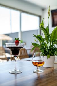two glasses of wine and a strawberry on a table at En Plo Boutique Suites in Oia