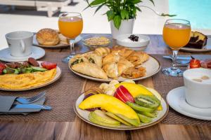 a table with plates of breakfast foods and drinks at En Plo Boutique Suites in Oia