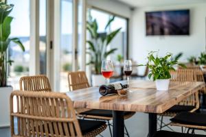 a wooden table with two glasses of wine at En Plo Boutique Suites in Oia