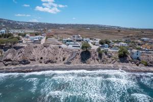 an aerial view of the ocean and a beach at En Plo Boutique Suites in Oia