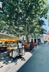 un grupo de mesas y sombrillas en una calle de la ciudad en Duplex de charme 80m2 au coeur d'Arles, 2 chambres en Arles