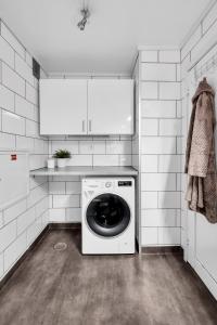 een witte wasruimte met een wasmachine bij Leilighet sentralt på Lund i Kristiansand in Kristiansand