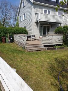 een huis met een veranda en een bank op een terras bij Leilighet sentralt på Lund i Kristiansand in Kristiansand