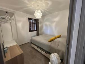 a bedroom with a bed with a yellow pillow on it at Appartement pour 2 personnes en ville avec terrasse in La Londe-les-Maures
