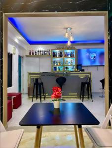 a room with a table and a bar with blue lights at Hotel Dubaird in Santo Domingo