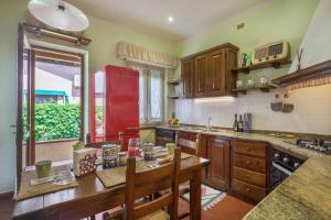a kitchen with a wooden table and a red refrigerator at Villa Luis in Pietrasanta