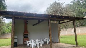 a patio with white tables and chairs under a pavilion at Pousada São Manoel in Valença