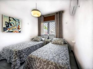 a bedroom with two beds and a window at Casa Limonero con parking gratis junto a centro histórico in Granada
