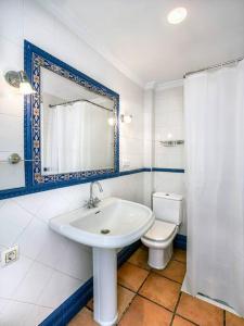 a bathroom with a sink and a toilet and a mirror at Casa Limonero con parking gratis junto a centro histórico in Granada +25 photos