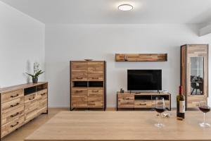 a living room with two wine glasses and a television at Atria Urban Gateway, 2BR Condo + Pool in Bucharest