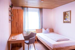 Zimmer mit einem Bett, einem Schreibtisch und einem Fenster in der Unterkunft Gasthof Rebstock in Stetten