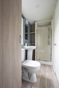a bathroom with a toilet and a sink at Borwick Lakes Holiday Caravan (Partial Lake View) in Borwick