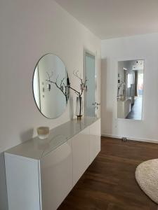 ein weißes Bad mit einem Wandspiegel in der Unterkunft Moderne Wohnung mit 4 Betten in Bochum