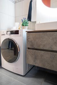 a white washing machine sitting next to a counter at Seaside Guesthouse in Kavala