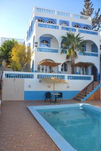 a building with a swimming pool in front of a building at The Sunrise Villa in Agadir