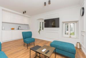 ein Wohnzimmer mit 2 blauen Stühlen und einem Tisch in der Unterkunft Palace Heritage Apartments in Makarska