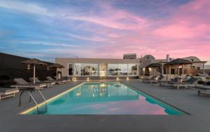 a swimming pool with lounge chairs and a resort at En Plo Boutique Suites in Oia