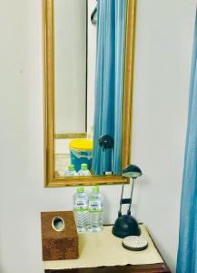 a mirror and some water bottles on a table at Sea Breeze Guest House in Negombo