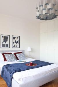 1 dormitorio blanco con 1 cama grande con manta azul en Apartments Vistula River by Arrenda, en Varsovia