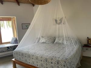 um quarto com uma cama e uma rede mosquiteira em villa colibri em Los Órganos