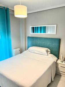 a bedroom with a large bed with a blue headboard at Hostal la Picota in Liencres