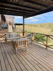 una terraza con bancos y vistas a una colina. en villa colibri, en Los Órganos