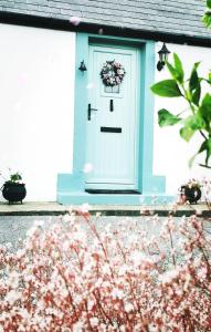 dom z niebieskimi drzwiami z wieniec w obiekcie New Listing - Ladybird Cottage - Donegal - Wild Atlantic Way w mieście Donegal