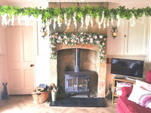 sala de estar con chimenea y flores en la pared en New Listing - Ladybird Cottage - Donegal - Wild Atlantic Way en Donegal