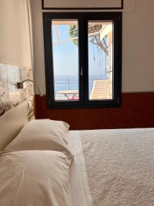 Schlafzimmer mit einem Bett und Meerblick in der Unterkunft Terramata Resort Case Vacanza in Santo Stefano al Mare