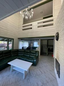 ein Wohnzimmer mit einem Sofa und einem Tisch in der Unterkunft Greenhouse in Voropayev