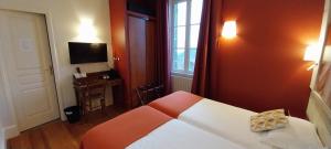 1 dormitorio con cama, ventana y TV en Logis hôtels Auberge du Château, en Saint-Rémy-de-Blot