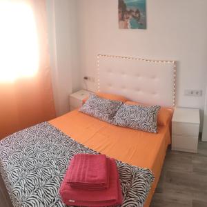 a bedroom with a large bed with orange sheets and pillows at Four Rooms in Valencia