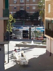 a group of people sitting in chairs in a courtyard with a bus at Four Rooms in Valencia