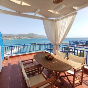 a table and chairs on a balcony with the ocean at Light Blue in Makry Gialos