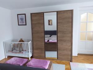 a large mirror in a room with a crib at Viktória Apartman in Szigetvár