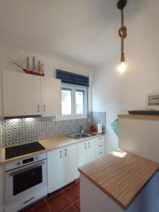 a kitchen with white cabinets and a counter top at Light Blue in Makry Gialos