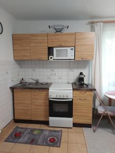 a kitchen with a stove and a microwave at Viktória Apartman in Szigetvár